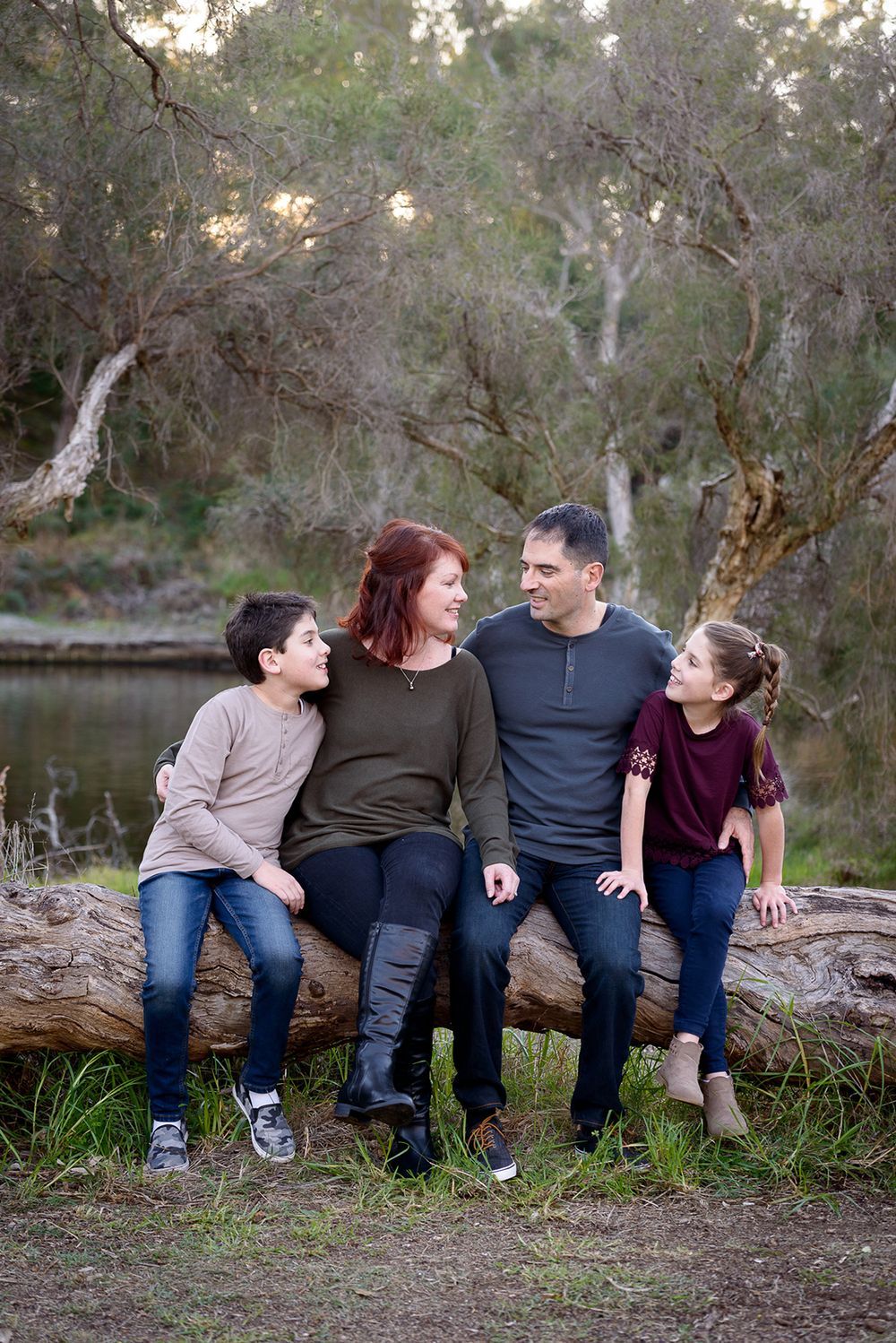 Family of four sitting on a log by the river - Kelly Chapman Photographer Perth
