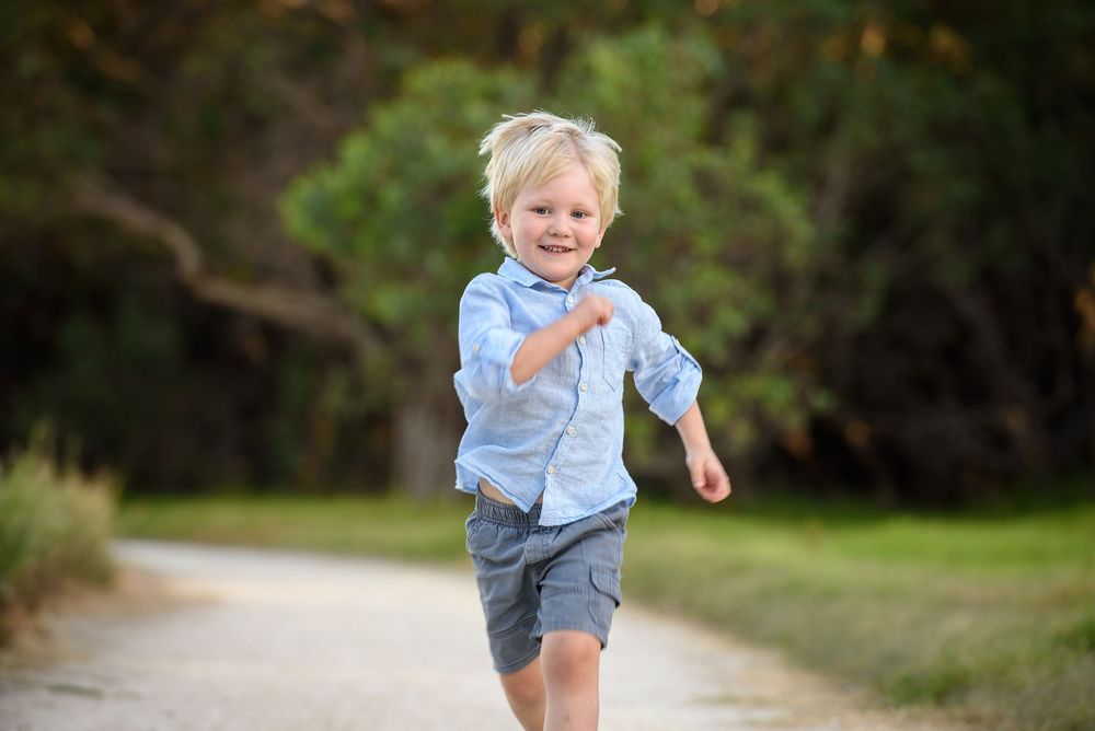 Smiling young boy running on a path towards camera - Kelly Chapman Photographer Perth