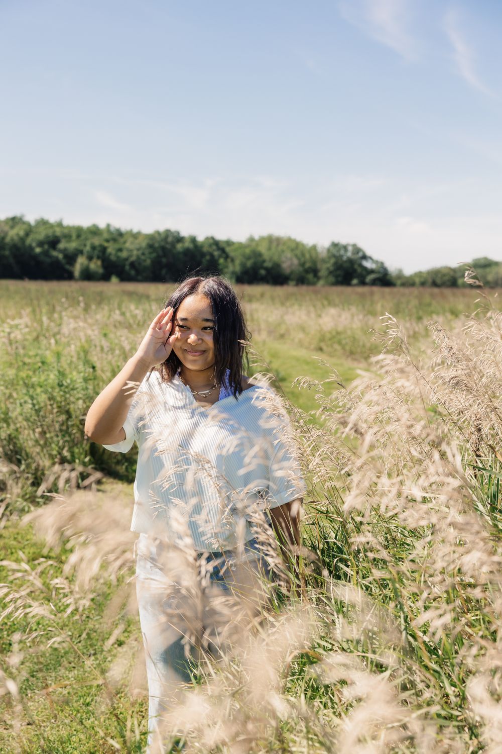 Summer portrait in sunny meadow with tall grass and blue sky.