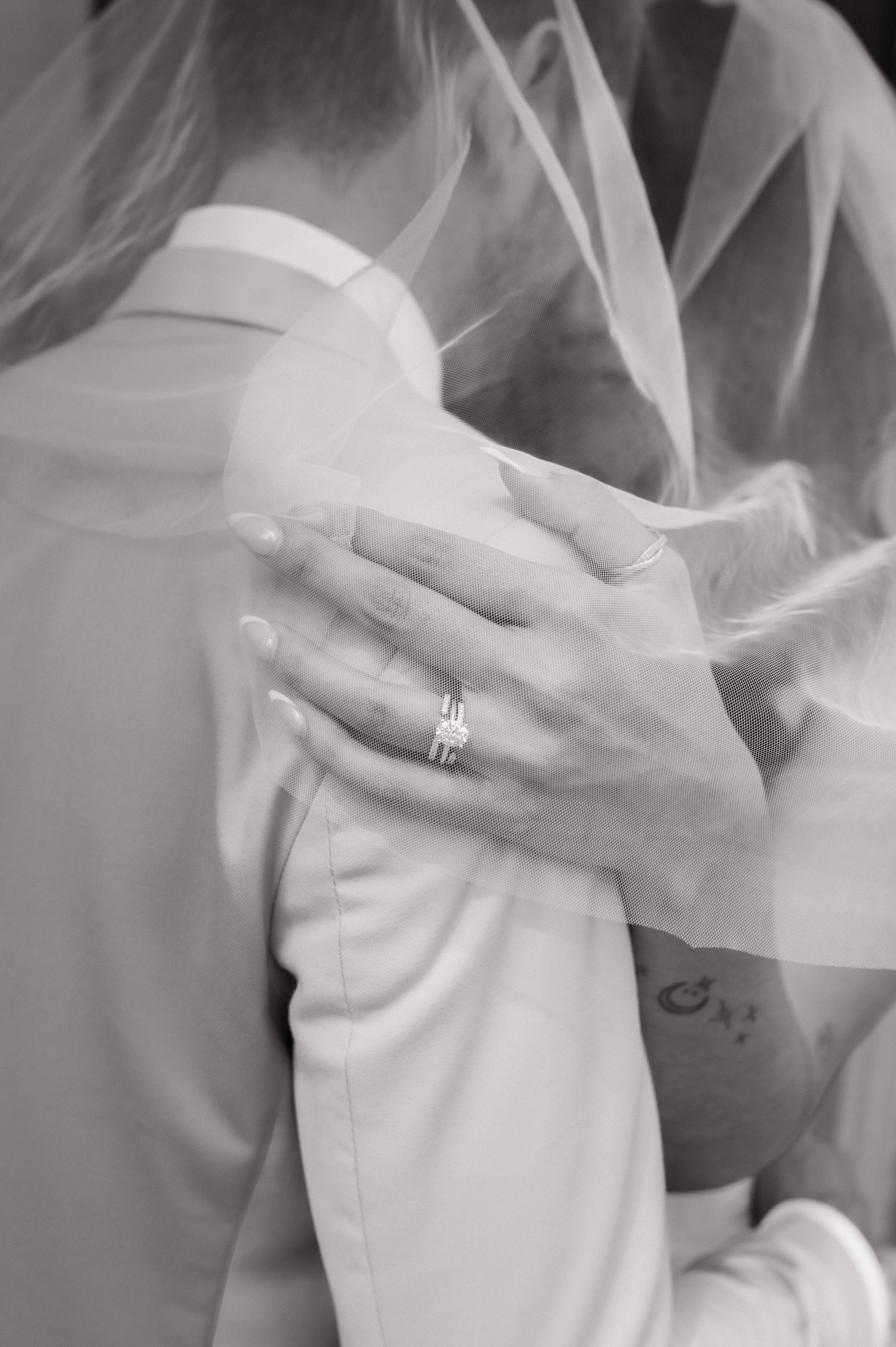 Black and white photo of bride and groom sharing a romantic kiss holding white bouquet High Point NC