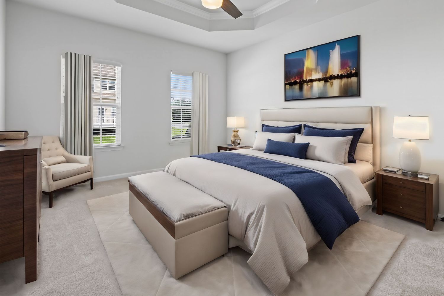 Elegant master bedroom with blue and grey decor featuring a plush upholstered bed and window views.