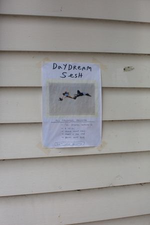Signs labeled 'Daydream' and 'Sesh' posted on a beige siding wall.