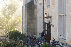 Stone building exterior with bicycles parked against the wall in late afternoon light.