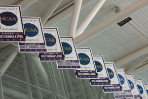 Row of NCAA championship banners hanging from a white ceiling.