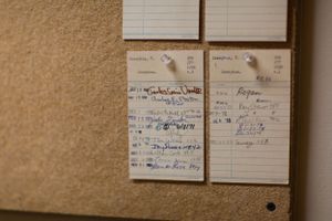 A series of index cards or notes arranged on a textured brown surface.
