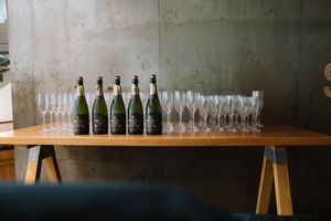 Champagne bottles and flute glasses arranged on wooden table for wedding reception.