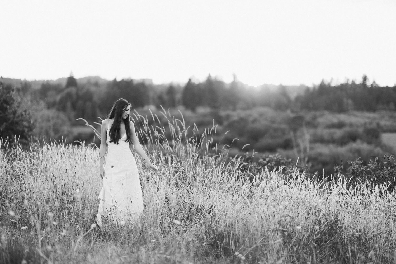 Person posing against white wall with climbing vines in black and white.