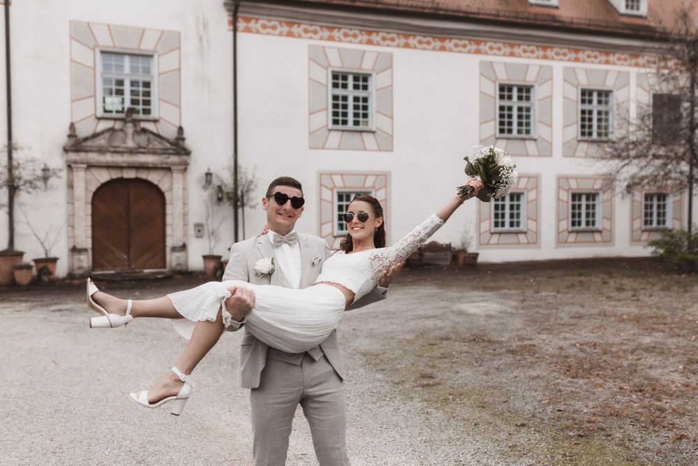 Romantischer Moment vor einem historischen europäischen Herrenhaus mit eleganter Steinfassade und traditionellen Fenstern.