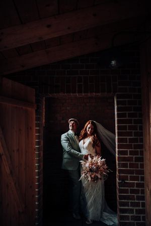 Ein Hochzeitspaar steht eingekuschelt aneinander. Sie haben eine Hochzeitsreportage im FarmInn in Wittingen mit Hey Elli Fotoreportagen.