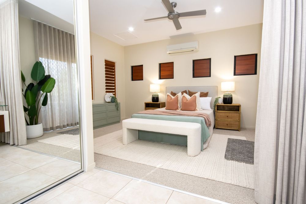Modern bedroom with mirrored closet doors, decorative wall art, and plush bedding.