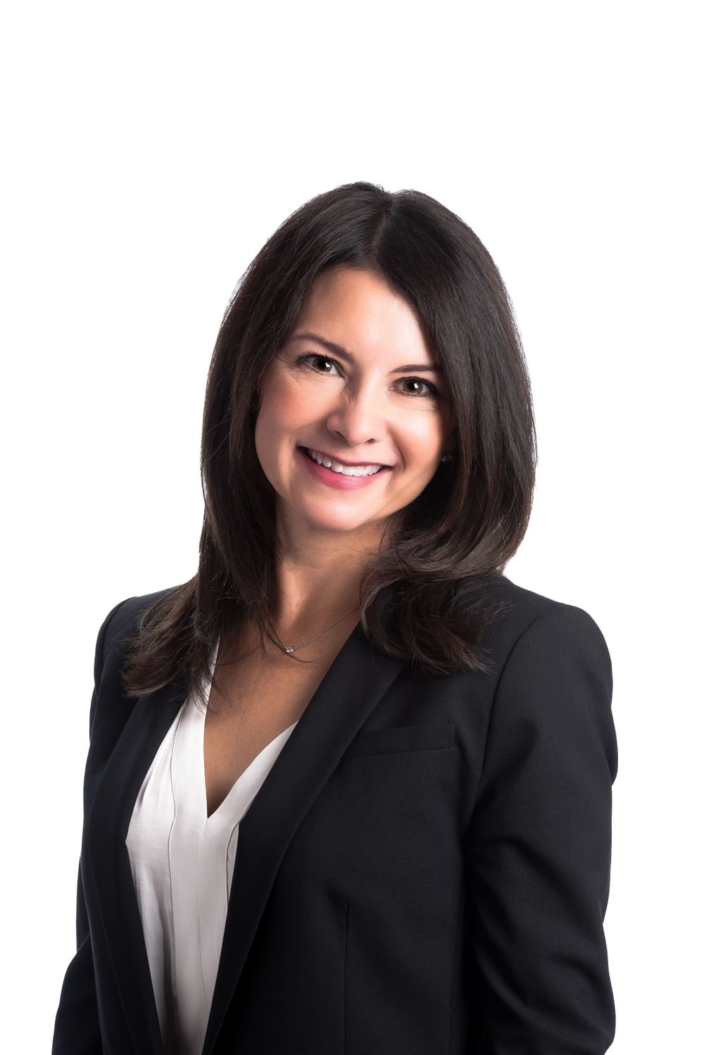 Professional headshot of woman in black blazer and white blouse against white background.