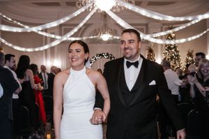 Newlyweds exit their reception under twinkling lights and draped ceiling decor. Photo at Charlottetown PE