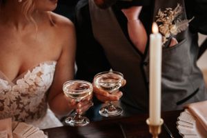Close-up of champagne coupes and wedding attire during an elegant reception. Photo at Charlottetown PE