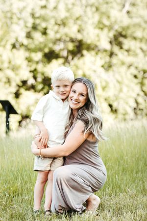 A warm outdoor portrait in a sunny meadow with neutral-toned clothing.