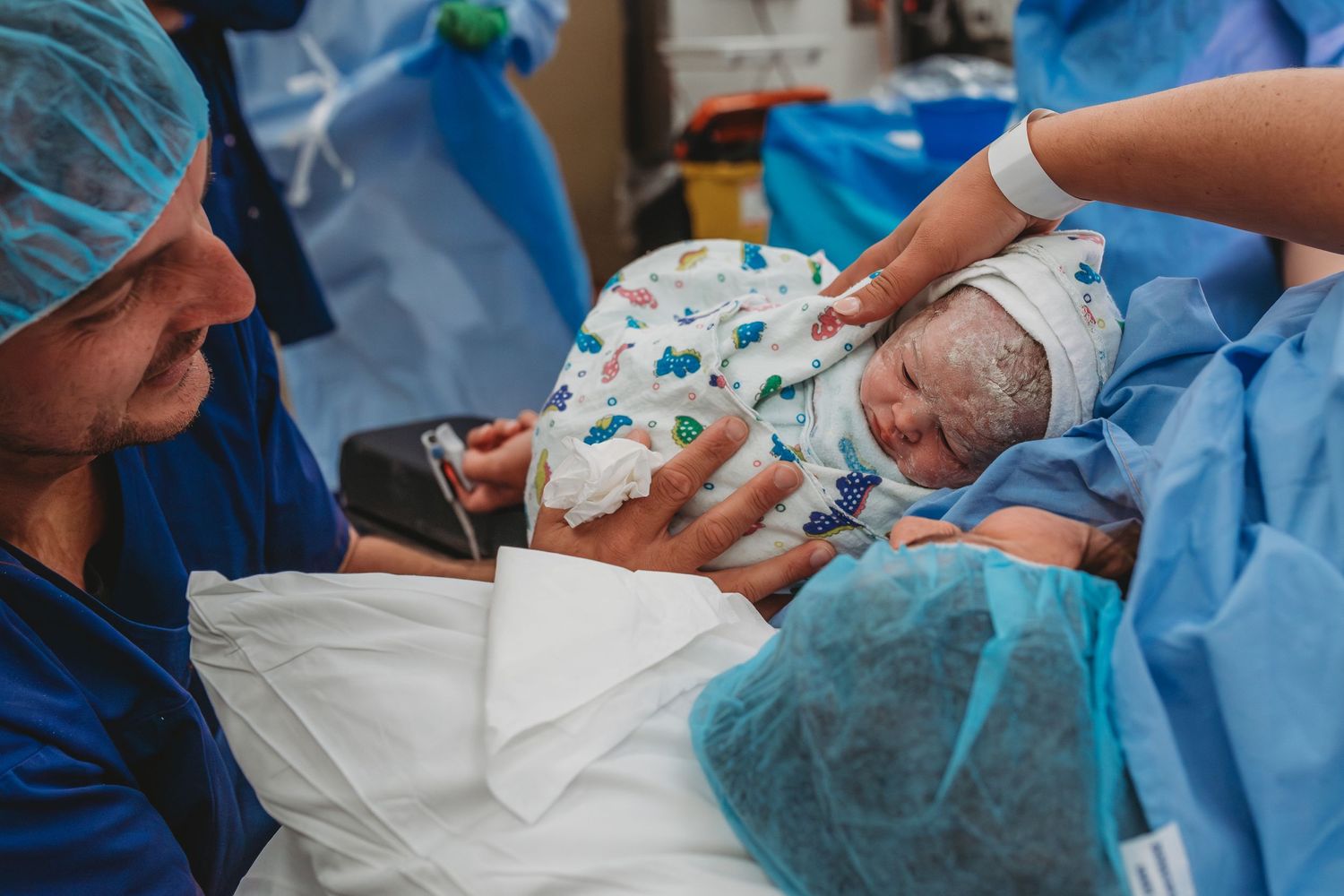 Healthcare professionals in blue medical gowns providing care in hospital setting.