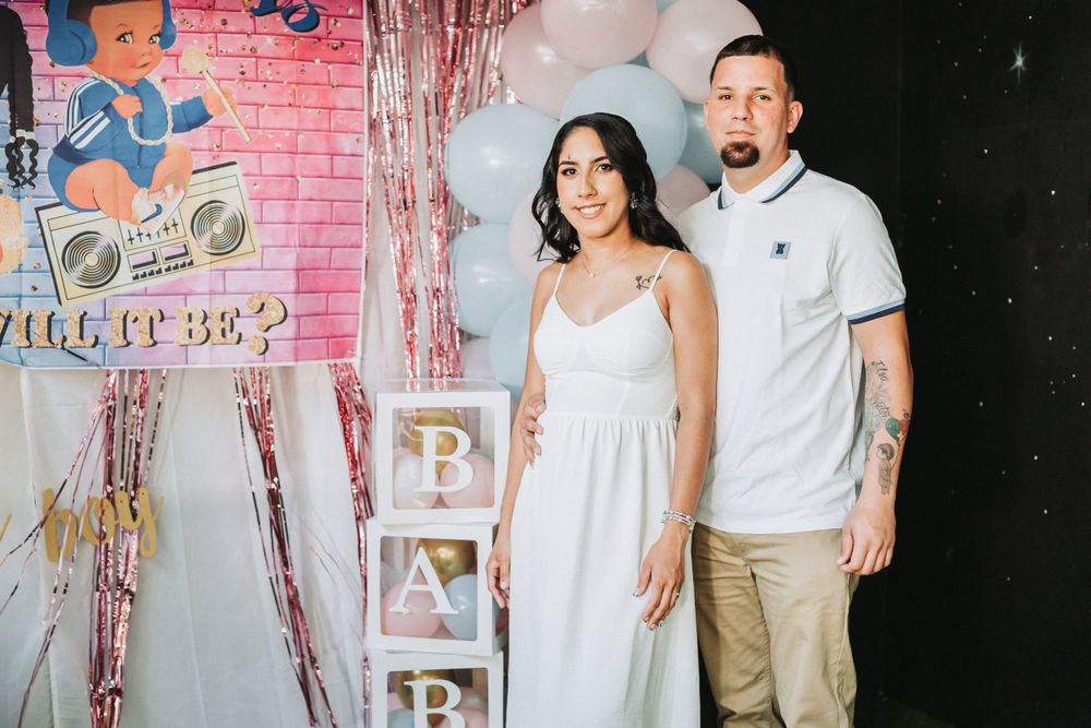 Pink and blue balloon arch decorates a party space with cartoon character backdrop.