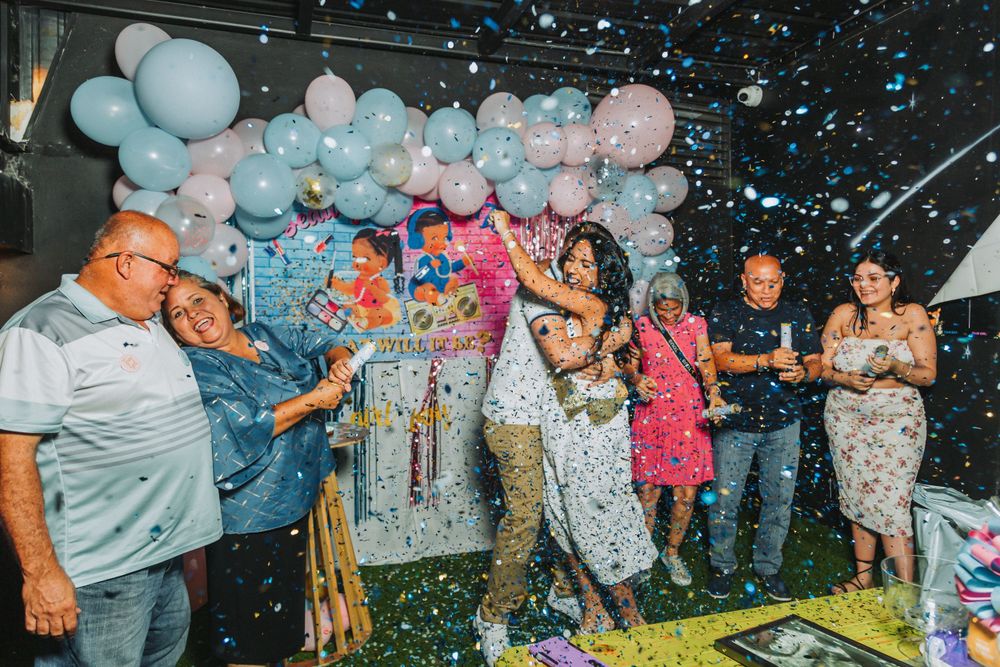 Party celebration with balloon decorations and confetti in the air.