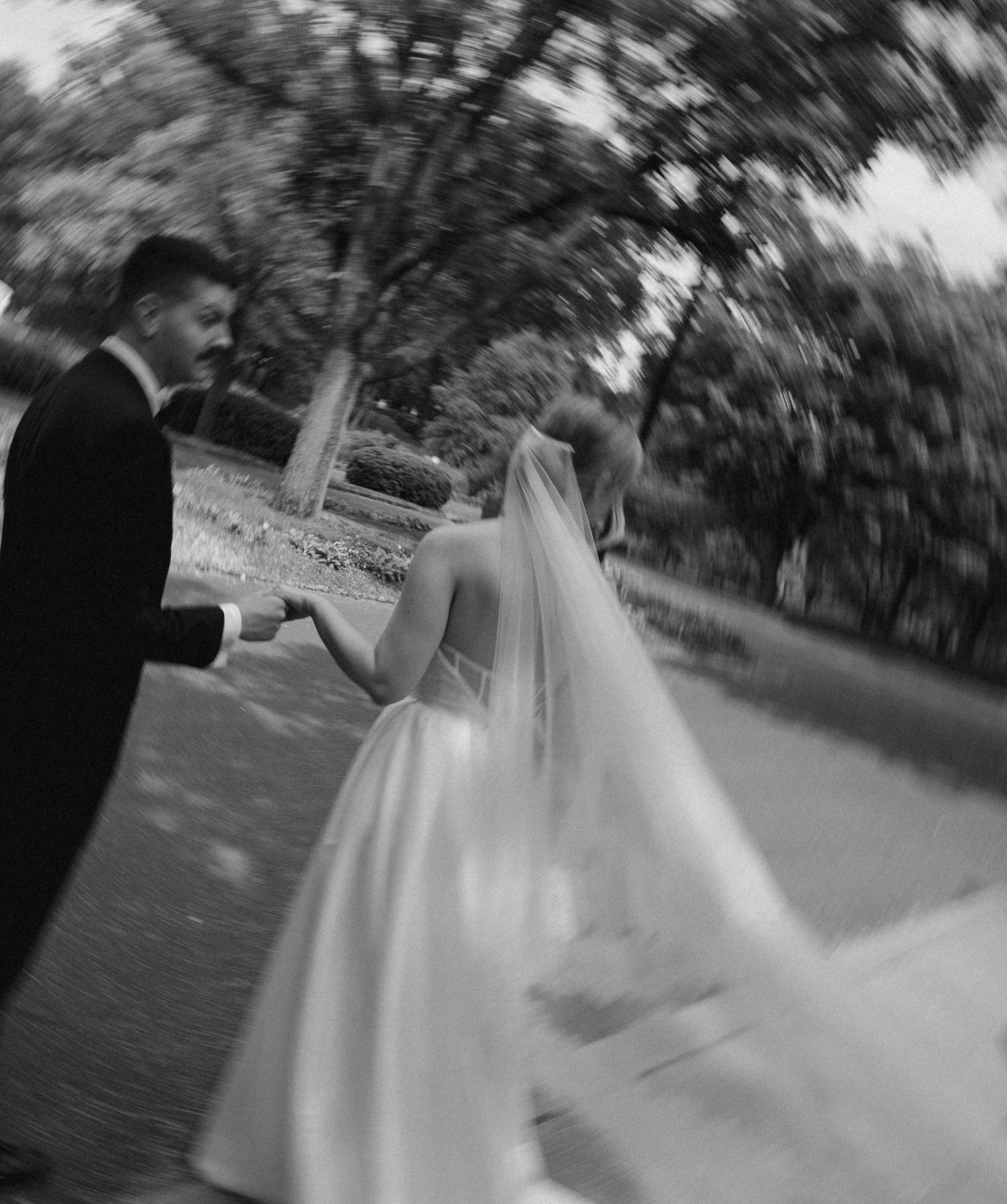 Black and white artistic shot of couple dancing on outdoor path.