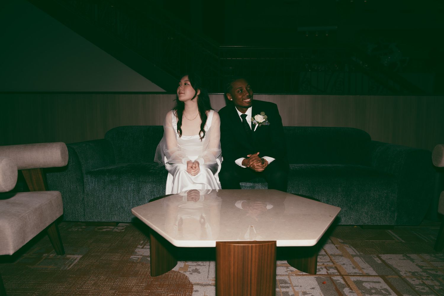 Couple sitting together at an elegant lounge table during a wedding reception.