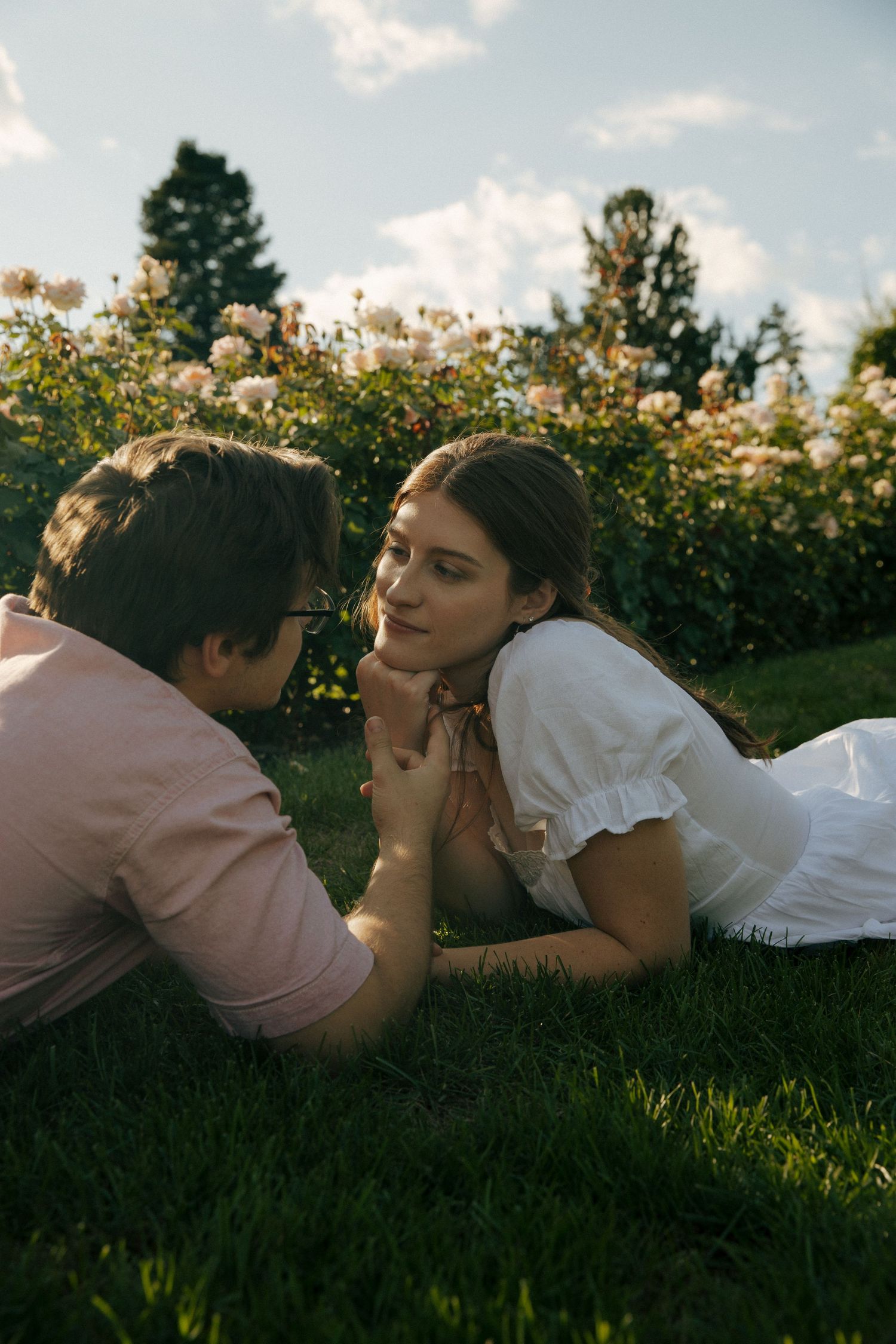 Intimate portrait in garden setting with soft afternoon light and blooming roses.