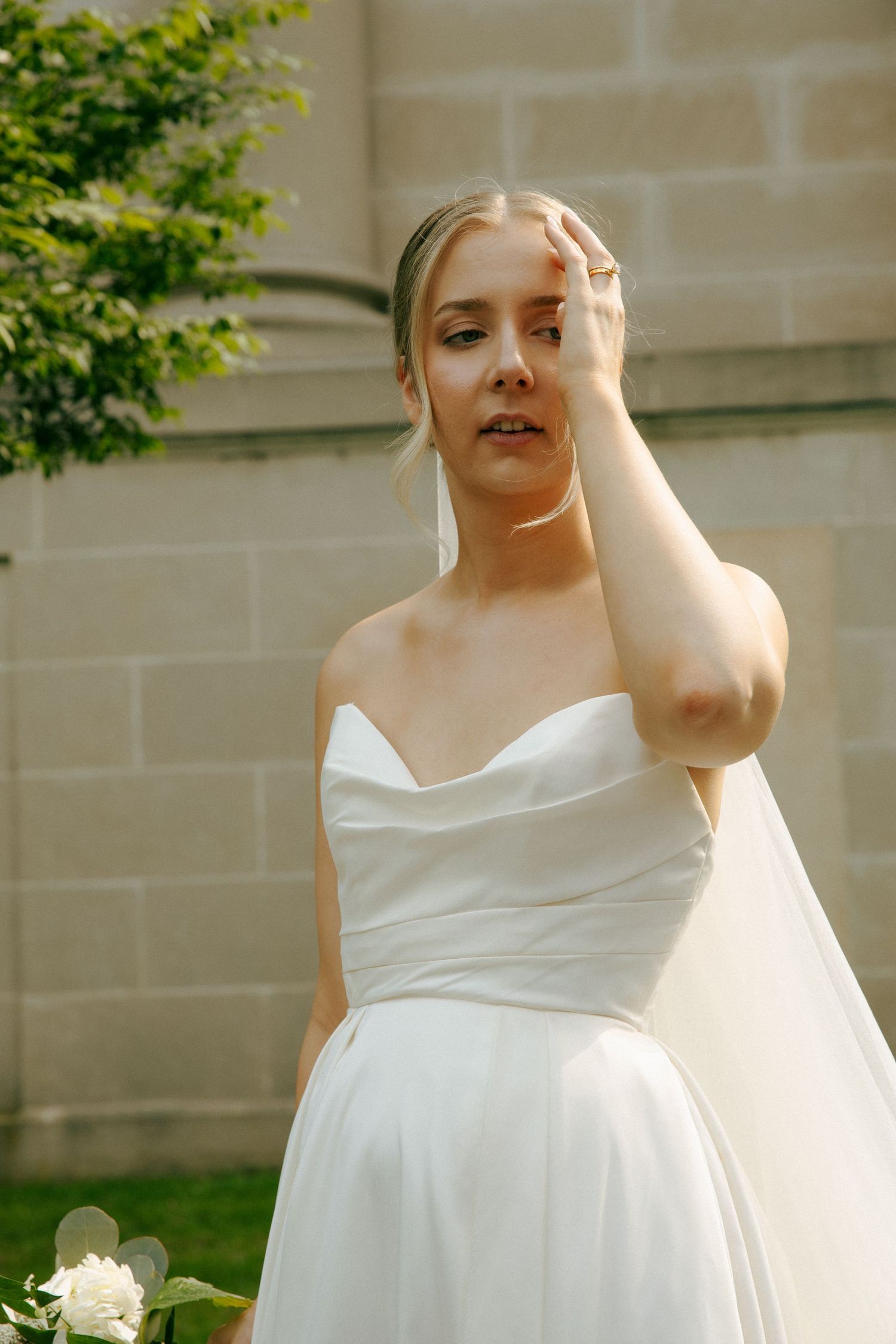 Classic white wedding dress with sweetheart neckline and flowing skirt captured in outdoor garden setting.