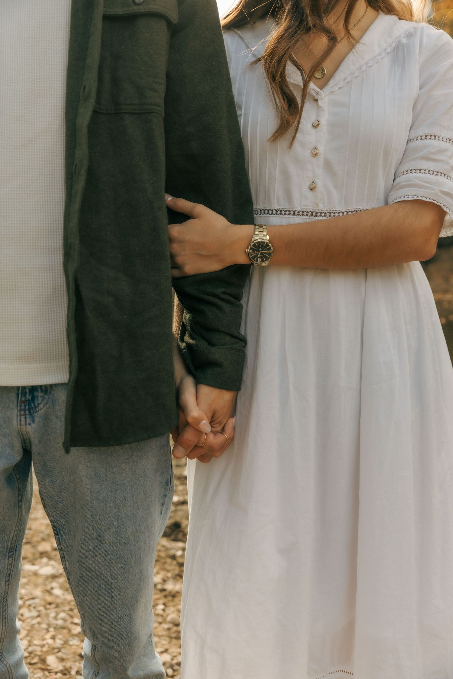 Close-up of contrasting outfits showing white dress and dark jacket details.