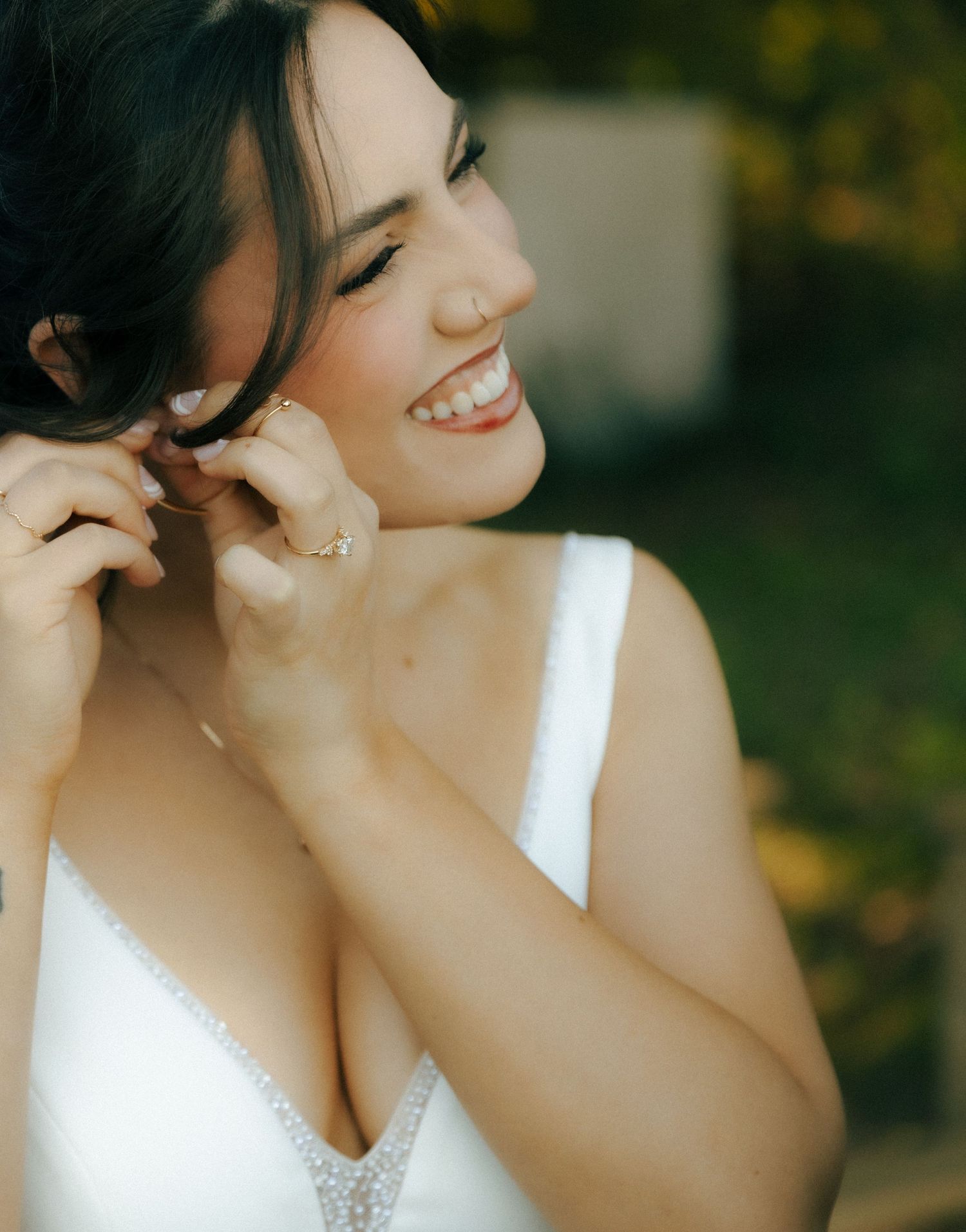 A joyful moment in white attire against a sunlit outdoor background.