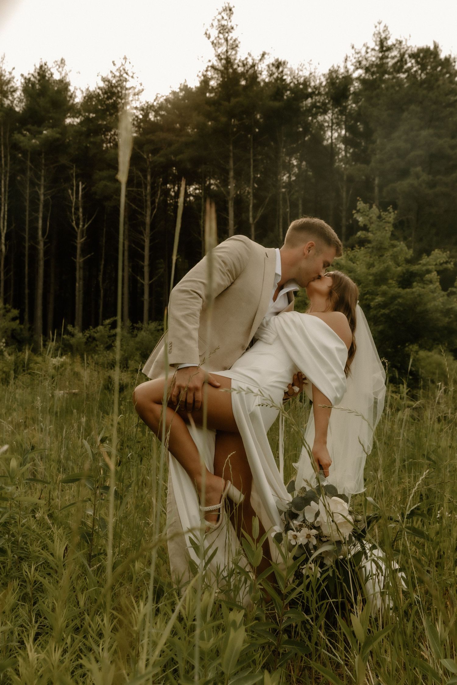 Dreamy wedding portrait in rustic outdoor setting with natural wilderness backdrop.
