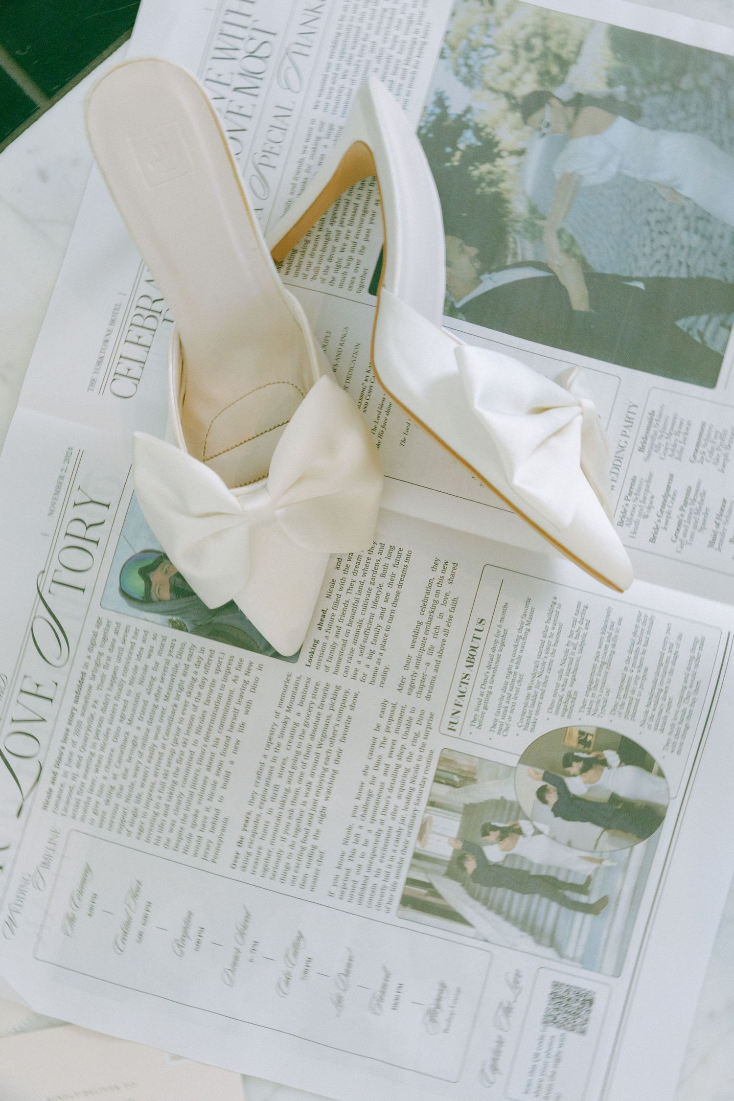 White bridal heels with large bow details displayed on a newspaper page.