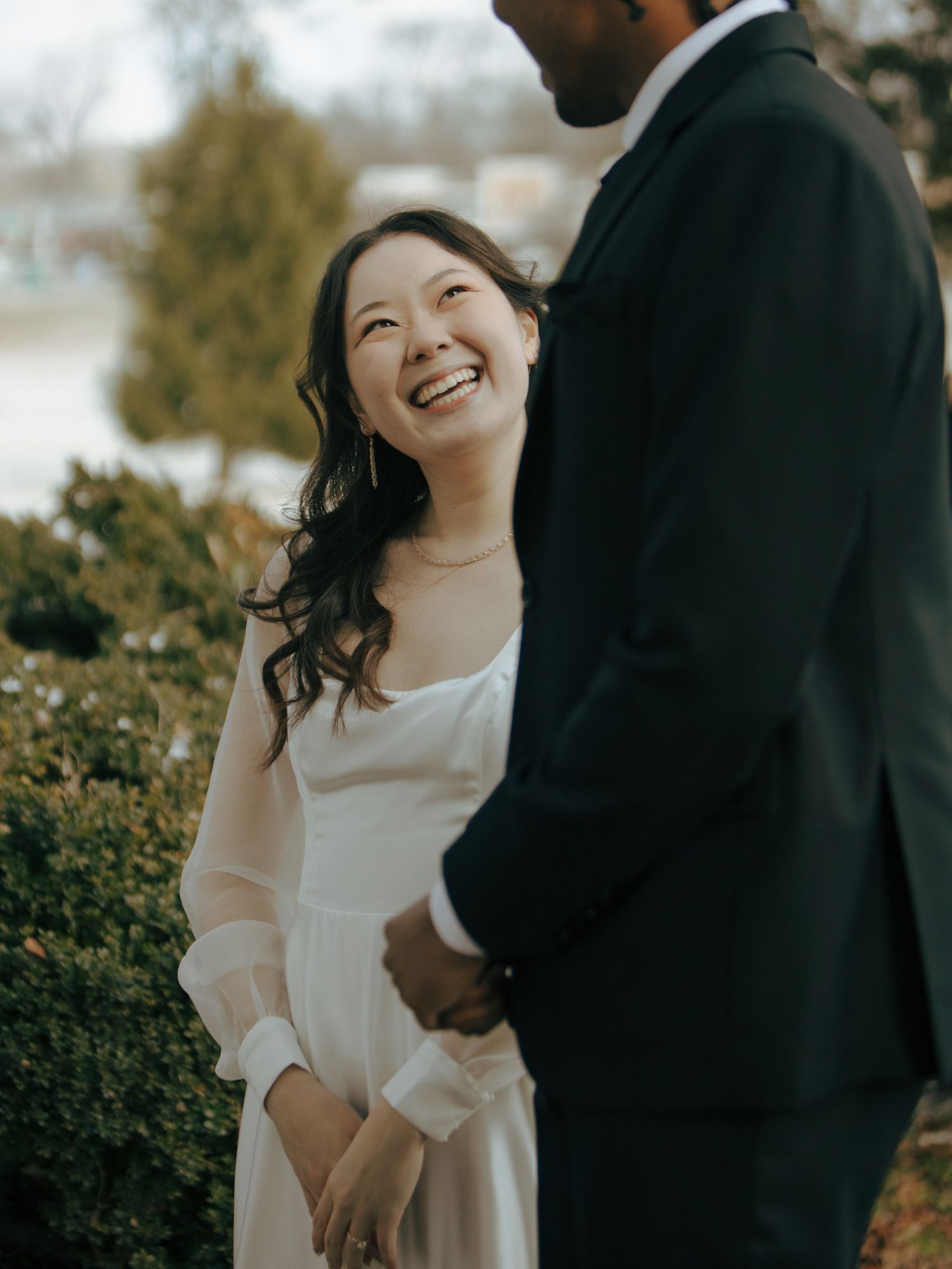 Candid moment of joy between newlyweds in garden setting.