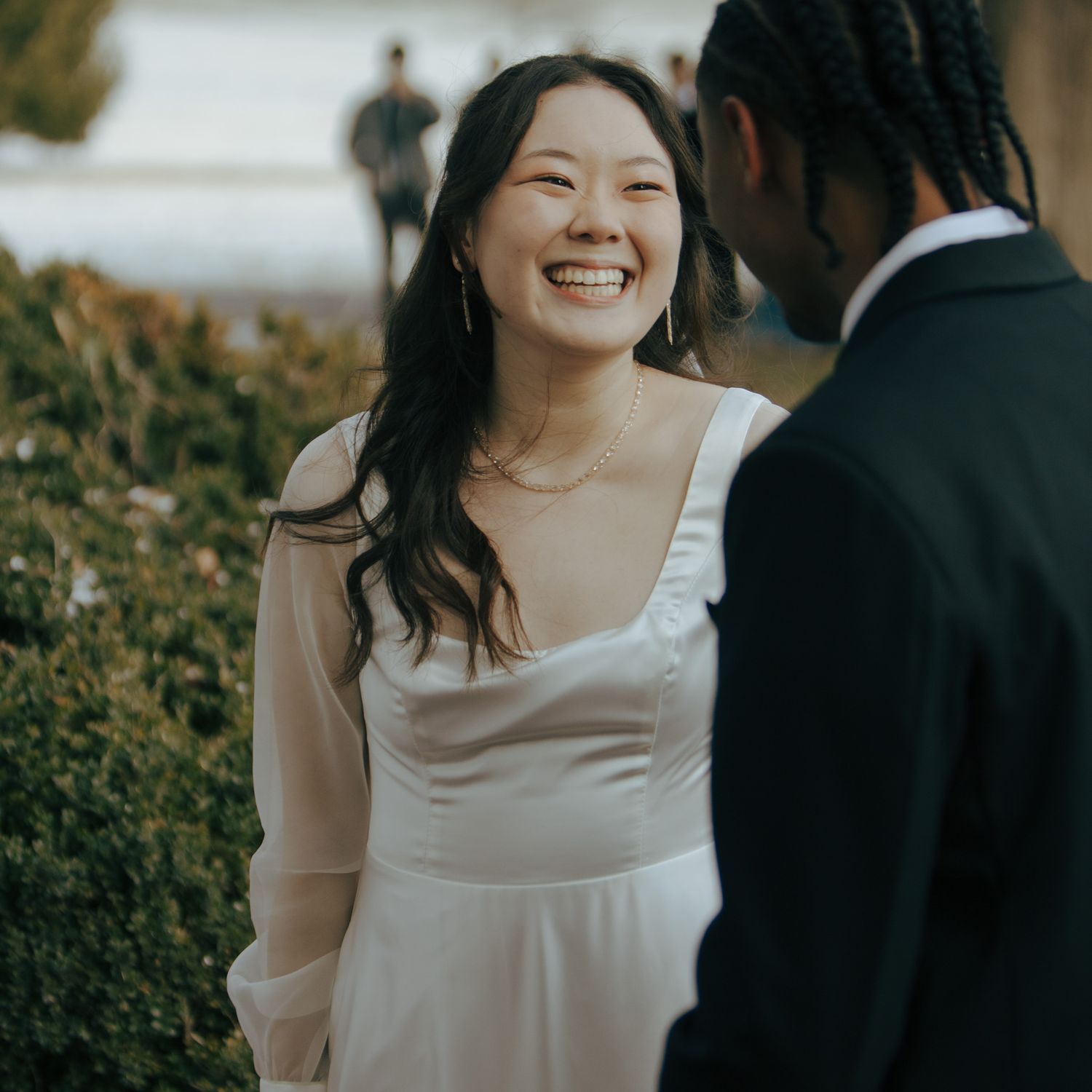Bride laughing joyfully during outdoor wedding photoshoot.