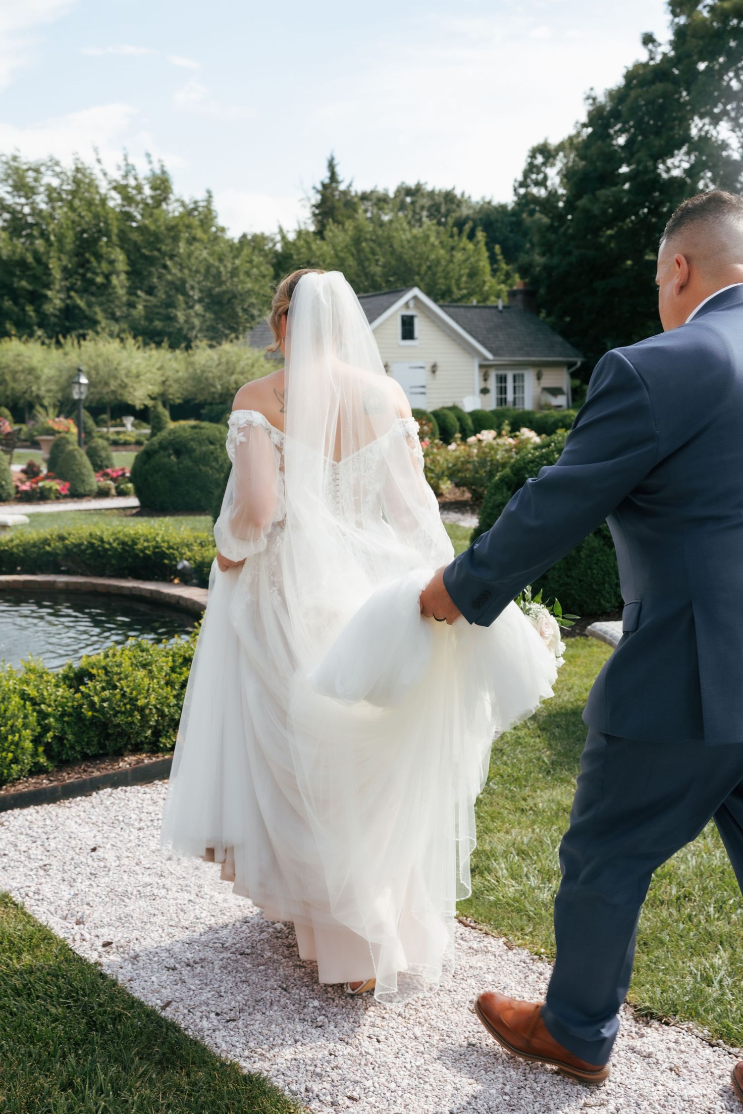 A series of wedding photos showing a bride in white dress and veil walking with someone in a navy suit along a gravel path.