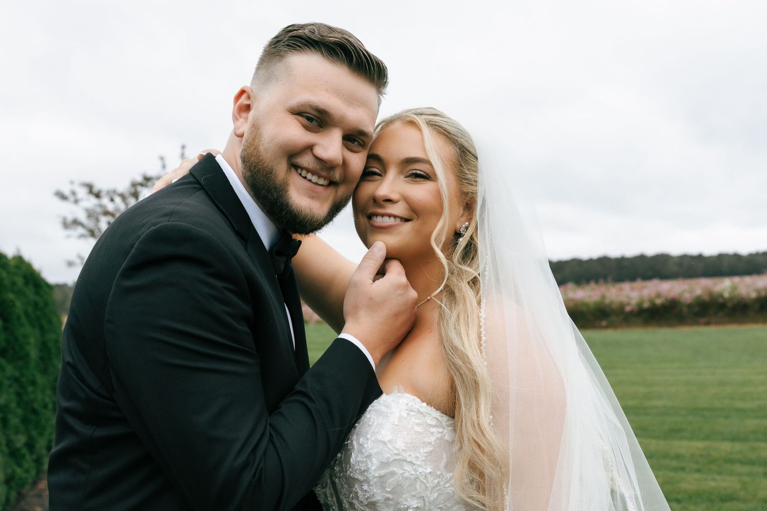 A bride and groom share a joyful moment together outdoors on their wedding day.