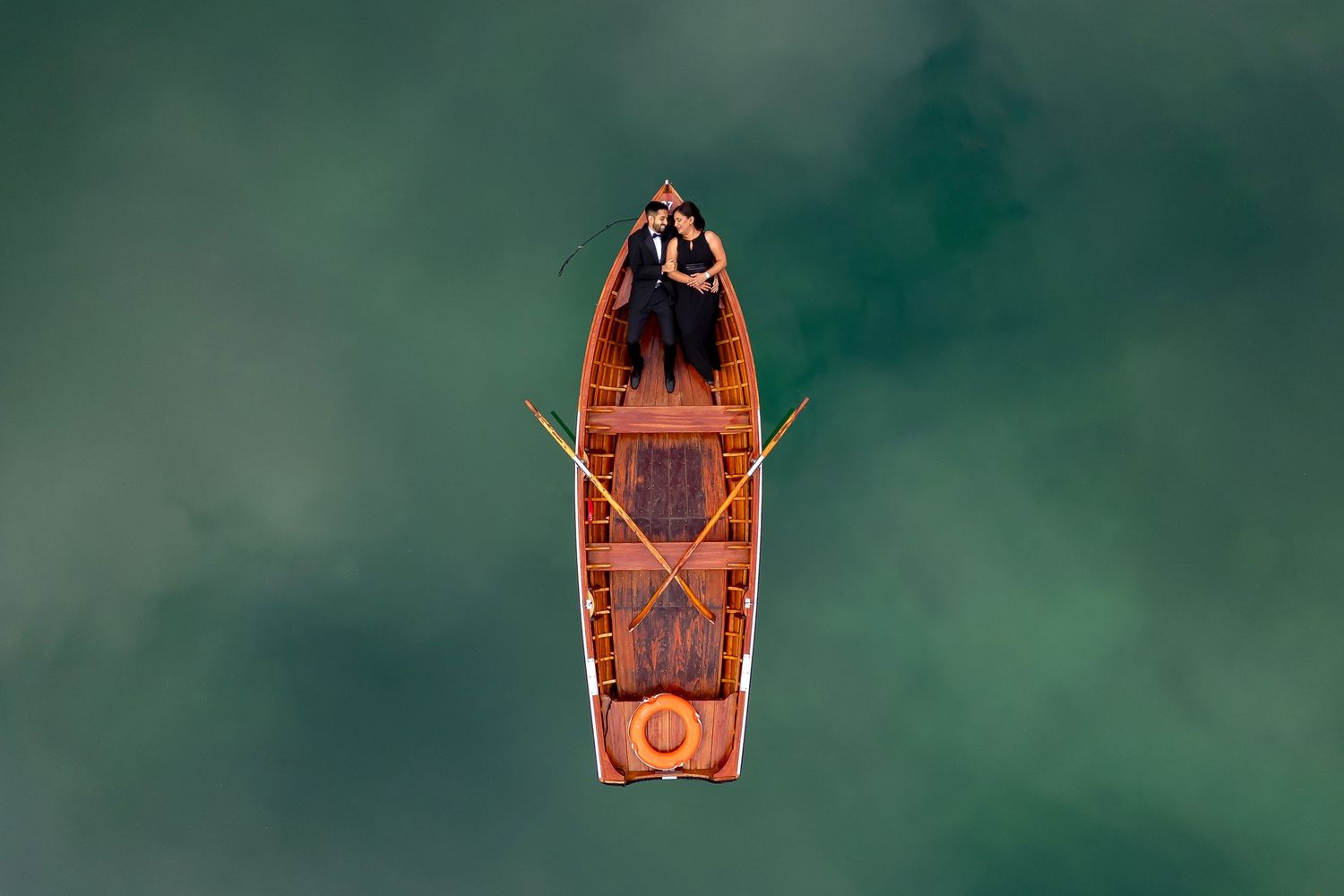 Foto Collective pre-wedding shoot. Couple in a boat on turquoise water in Dolomites, Italy.
