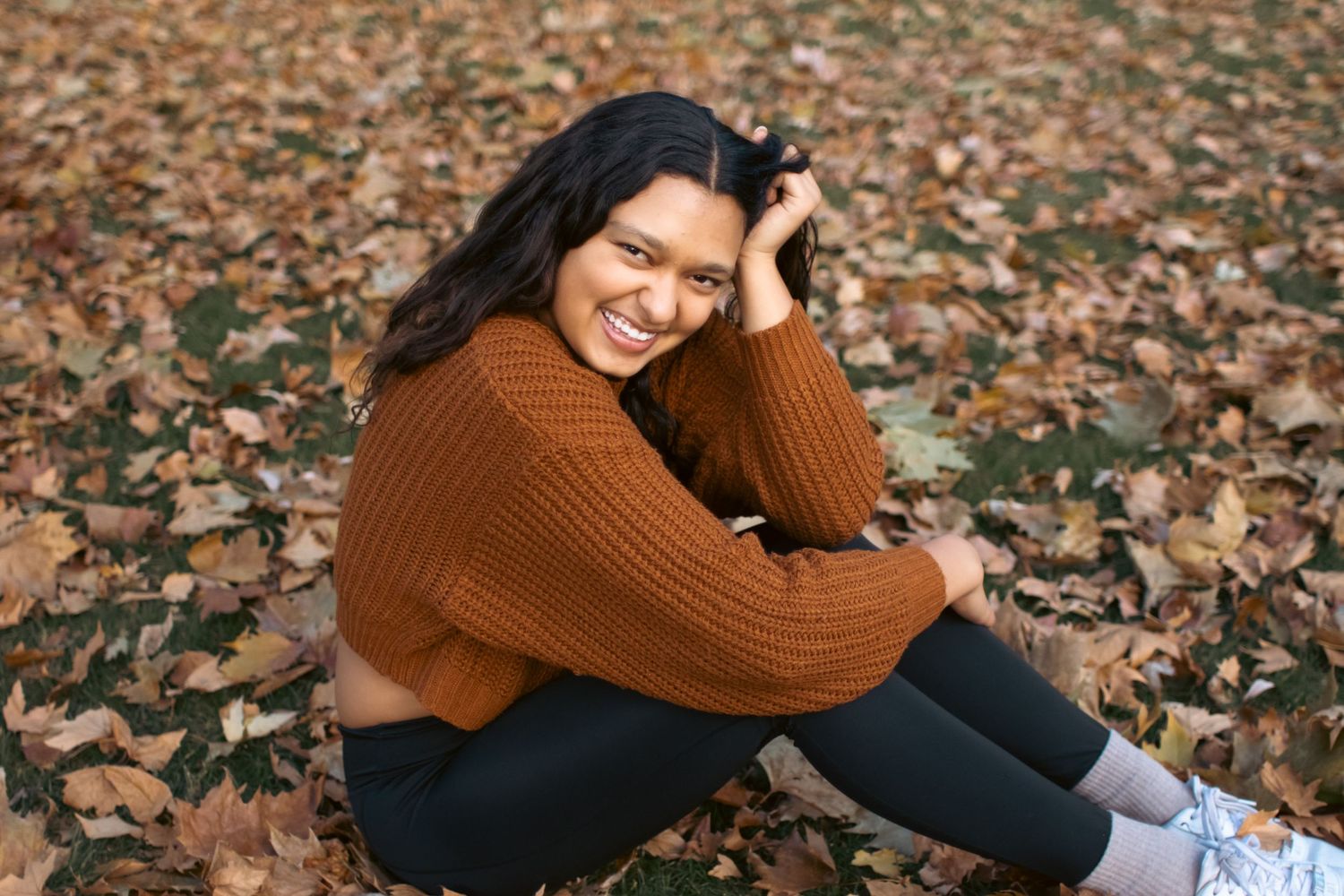 A young teenage girl smiling in the park.