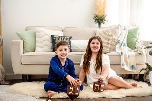 Family lounging together in white and blue outfits during a cozy holiday photoshoot with Christmas decor.