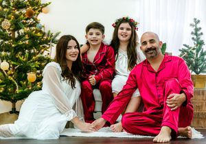 Holiday family photos with matching red and white outfits in front of a decorated Christmas tree.
