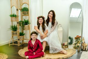 Modern holiday photoshoot with family members in coordinated outfits against a minimalist backdrop.
