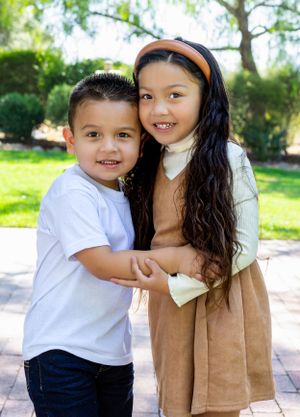 Sweet candid moments captured in sunny garden setting.