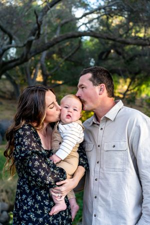 Sweet family moments captured under oak trees in natural lighting.