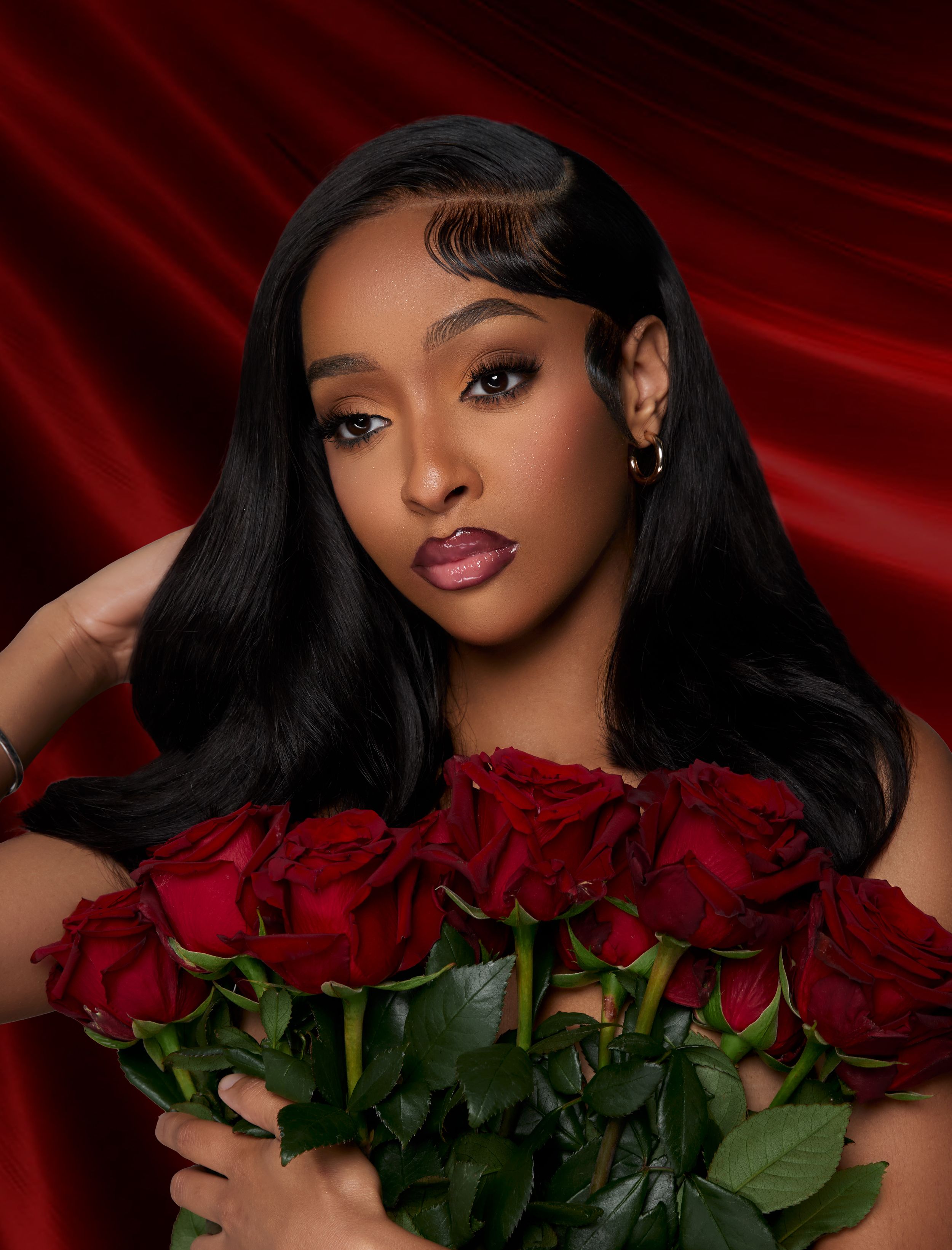 Elegant portrait featuring red roses against luxurious red drapery.