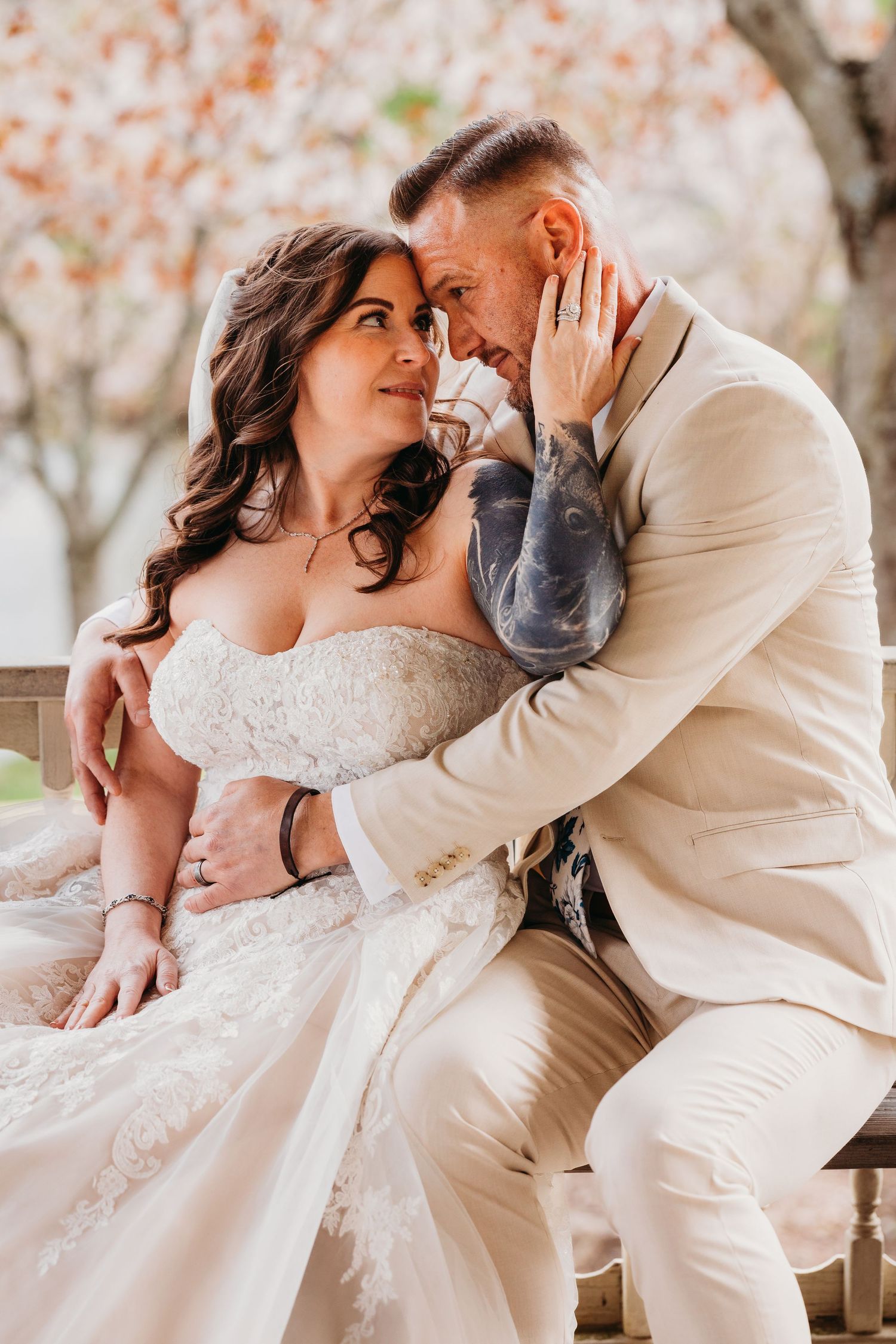 Romantic spring wedding portraits with cherry blossoms in the background.