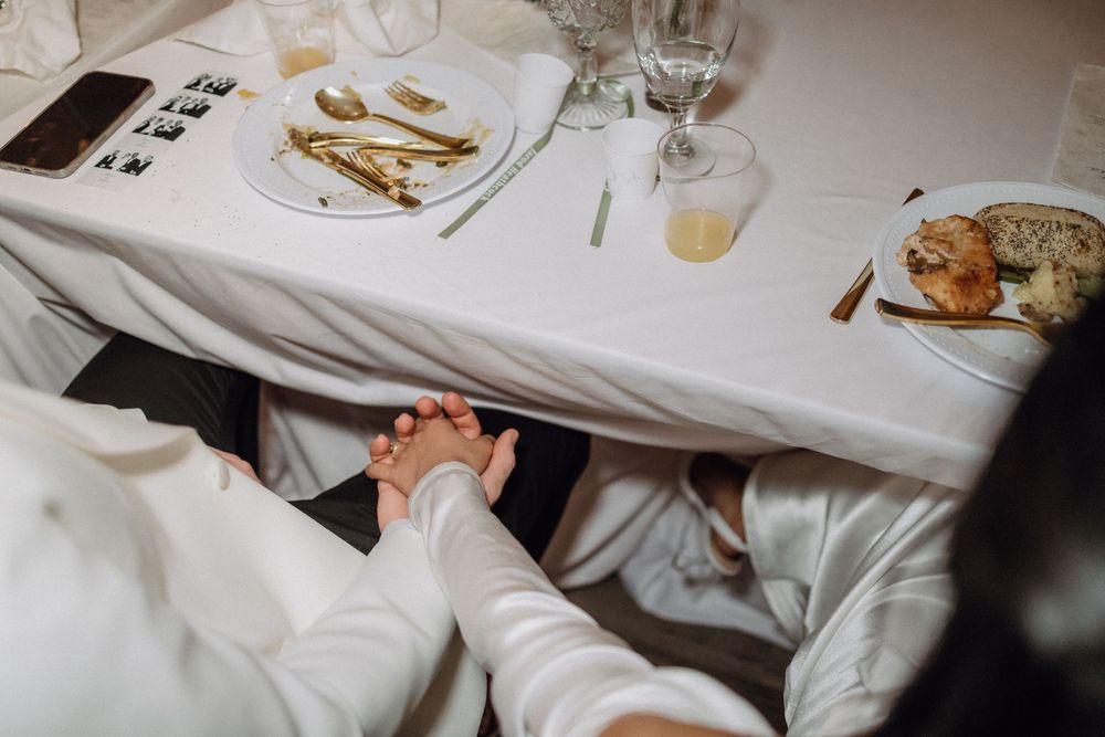 Wedding reception table settings with elegant place settings and white linens.