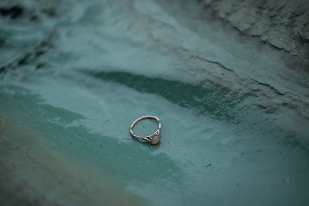 Detailed shots of a ring against a textured teal background.