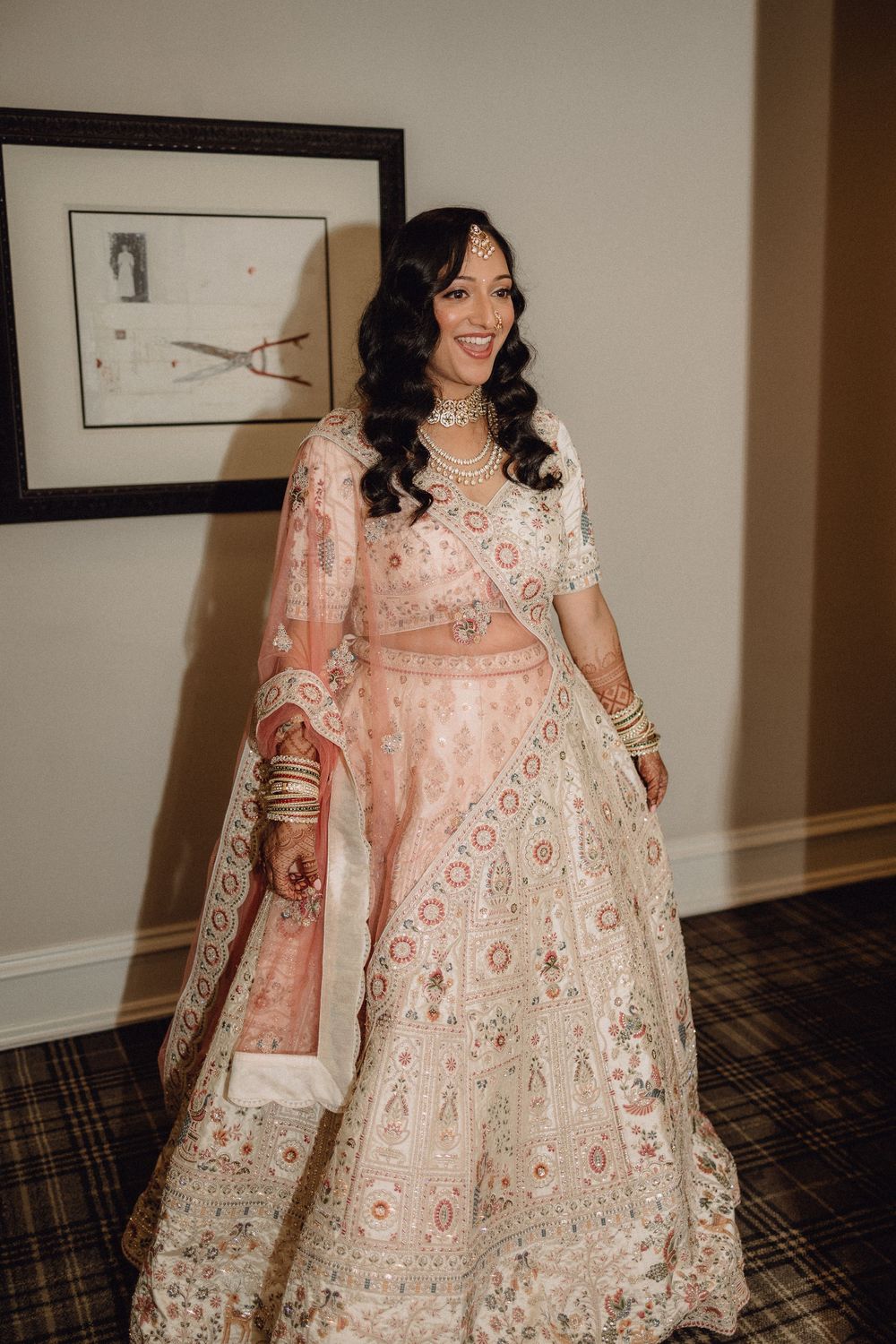 Elegant peach and white embroidered lehenga outfit displayed in a hotel hallway.