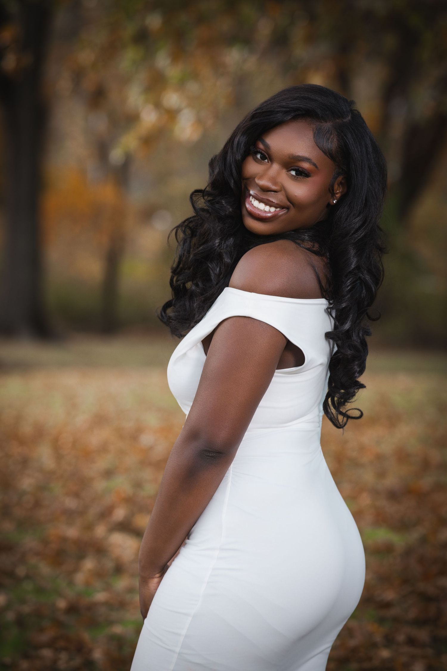 Outdoor portrait in a vibrant blue dress against natural green background.
