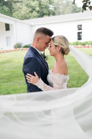 Wedding veil flows dramatically during romantic outdoor portrait session at Farmington Polo Club