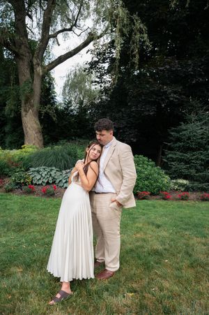Couple shares tender moments in garden setting wearing light summer attire. Woodwinds Branford CT