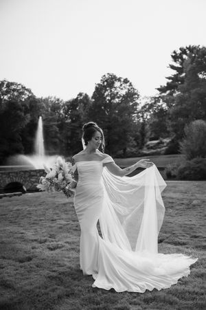 Bride twirls flowing white dress in dramatic black and white portrait series. Aqua Turf