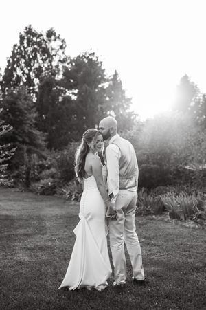 A romantic black and white portrait of a couple embracing in a sunlit garden setting at Kalmia Garden at Gastler Farm